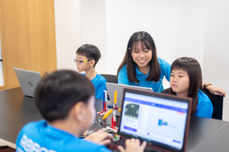 Students learning coding with a coach at Roboto Coding Academy in Singapore