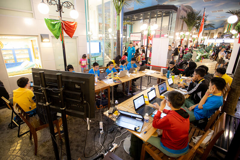 CodeFest hackathon venue with kids coding at tables