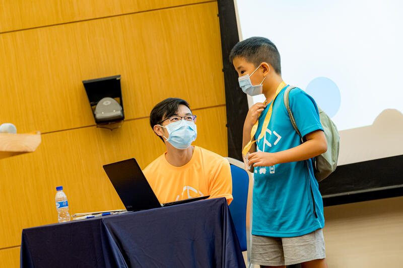 Instructor helping student with coding at CodeFest event