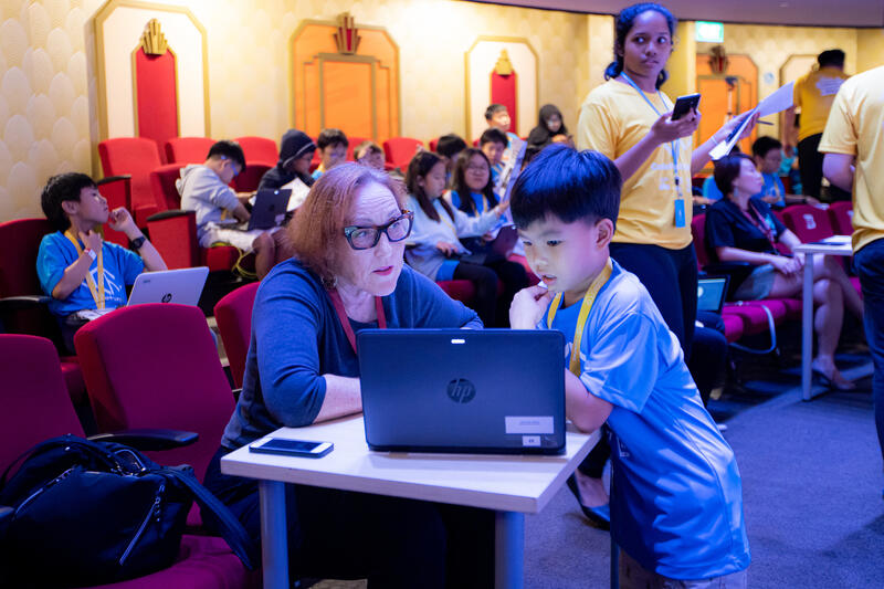 Judge reviewing student project at CodeFest competition