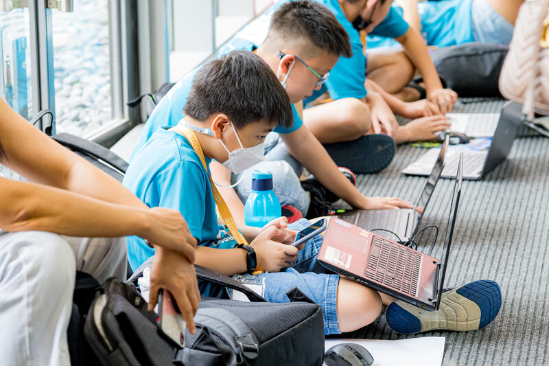Kids coding together on the floor at CodeFest event