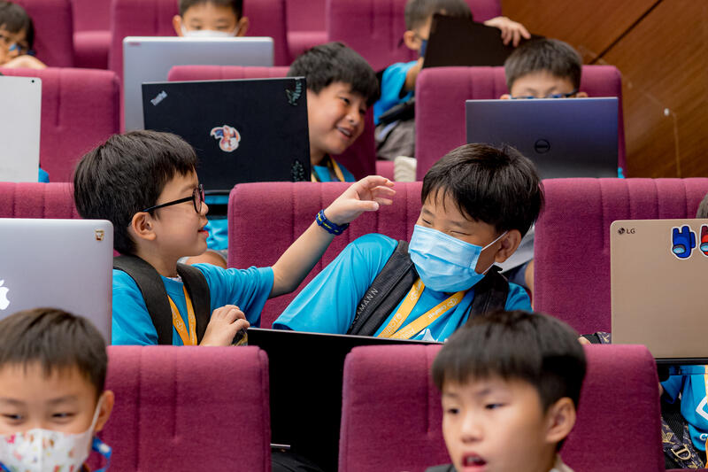 Kids collaborating on laptops at CodeFest coding hackathon