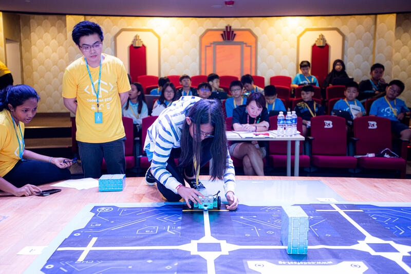 Student testing robot on competition mat at CodeFest