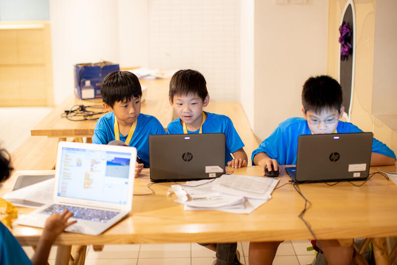 Young coders working on laptops at CodeFest hackathon
