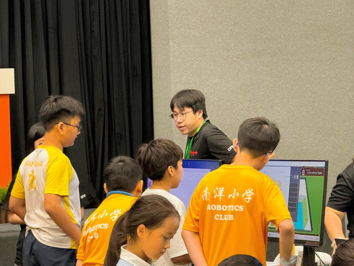 Coach guiding Nanyang Primary School Robotics Club students