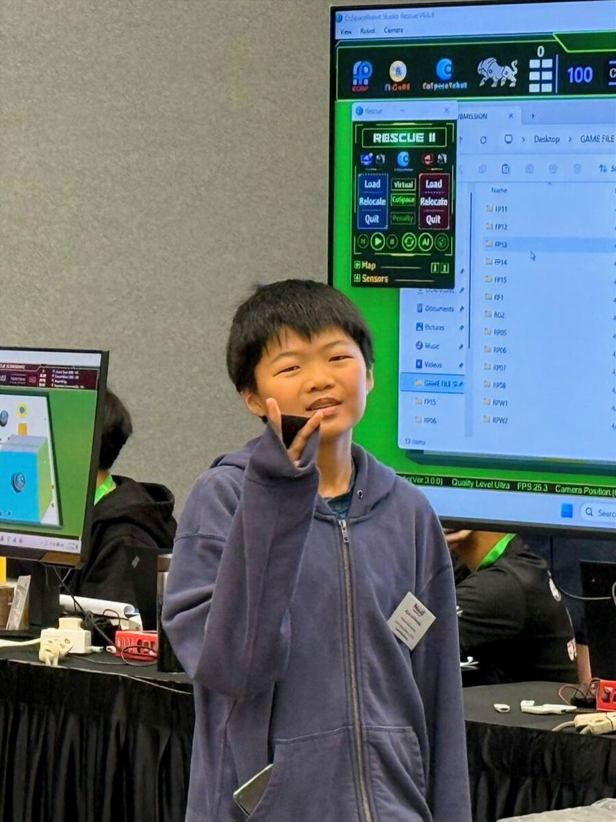 Student smiling at CoSpace Rescue station during RoboCup 2026