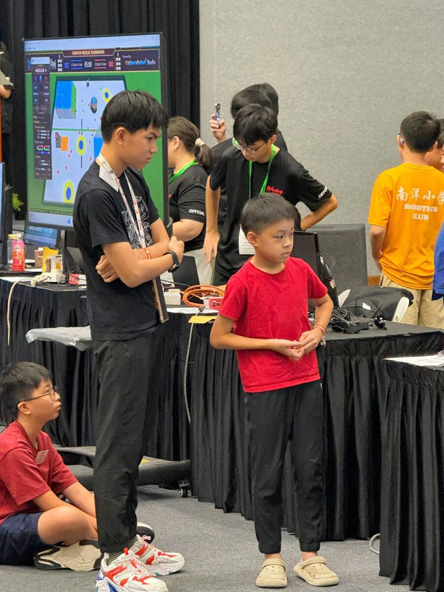 Students watching CoSpace Rescue scoreboard at competition