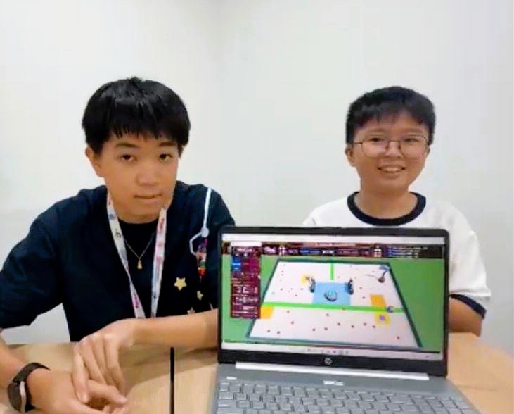 Two students showing CoSpace Rescue simulation on laptop