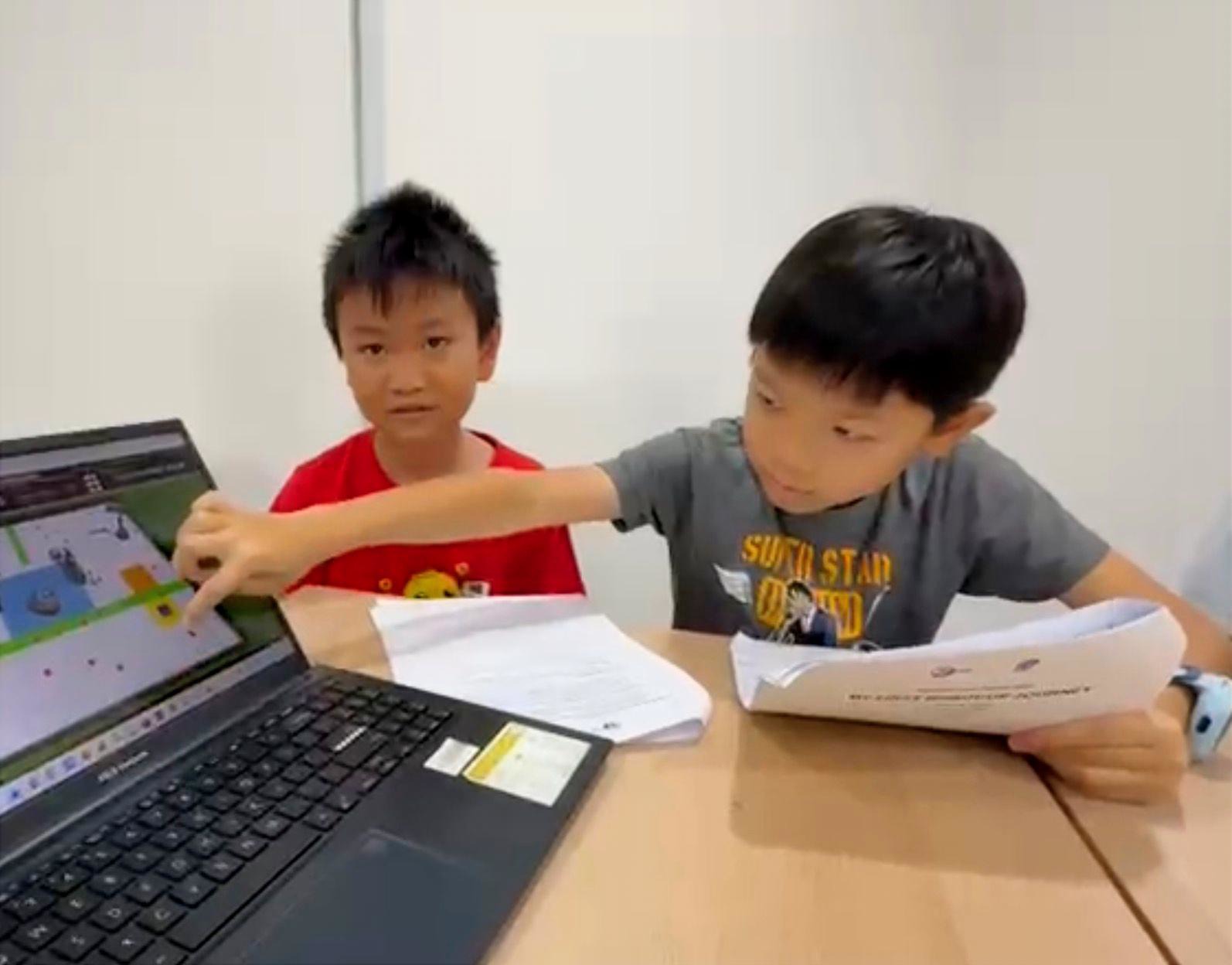 Two students pointing at CoSpace Rescue screen